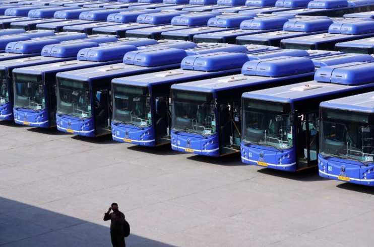 a-man-and-behind-him-many-electric-buses-in-ocean-blue-color-are-standing