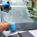 Skilled technicians installing or repairing a car windshield with precision.