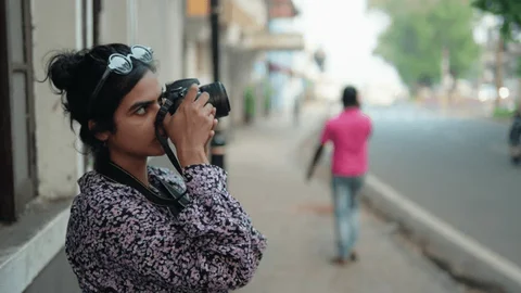 A Lady with Camera doing Photography in an Indian Street