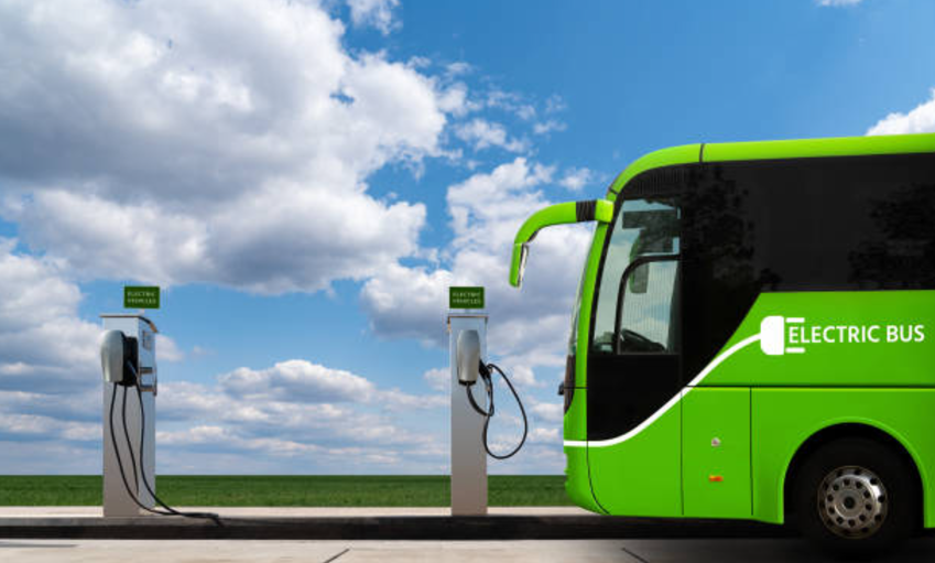 Electric-Vehicles-Charging-Stations-in-India - Green Electric Bus on a Charging Station Near a Highway - Illustration