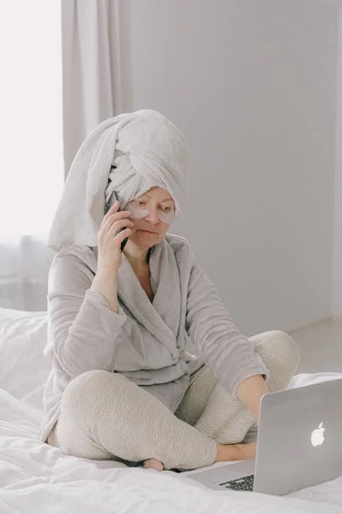 pexels-photo-3846132 - mid age woman making a phone call sitting early on bed while a towel on her head